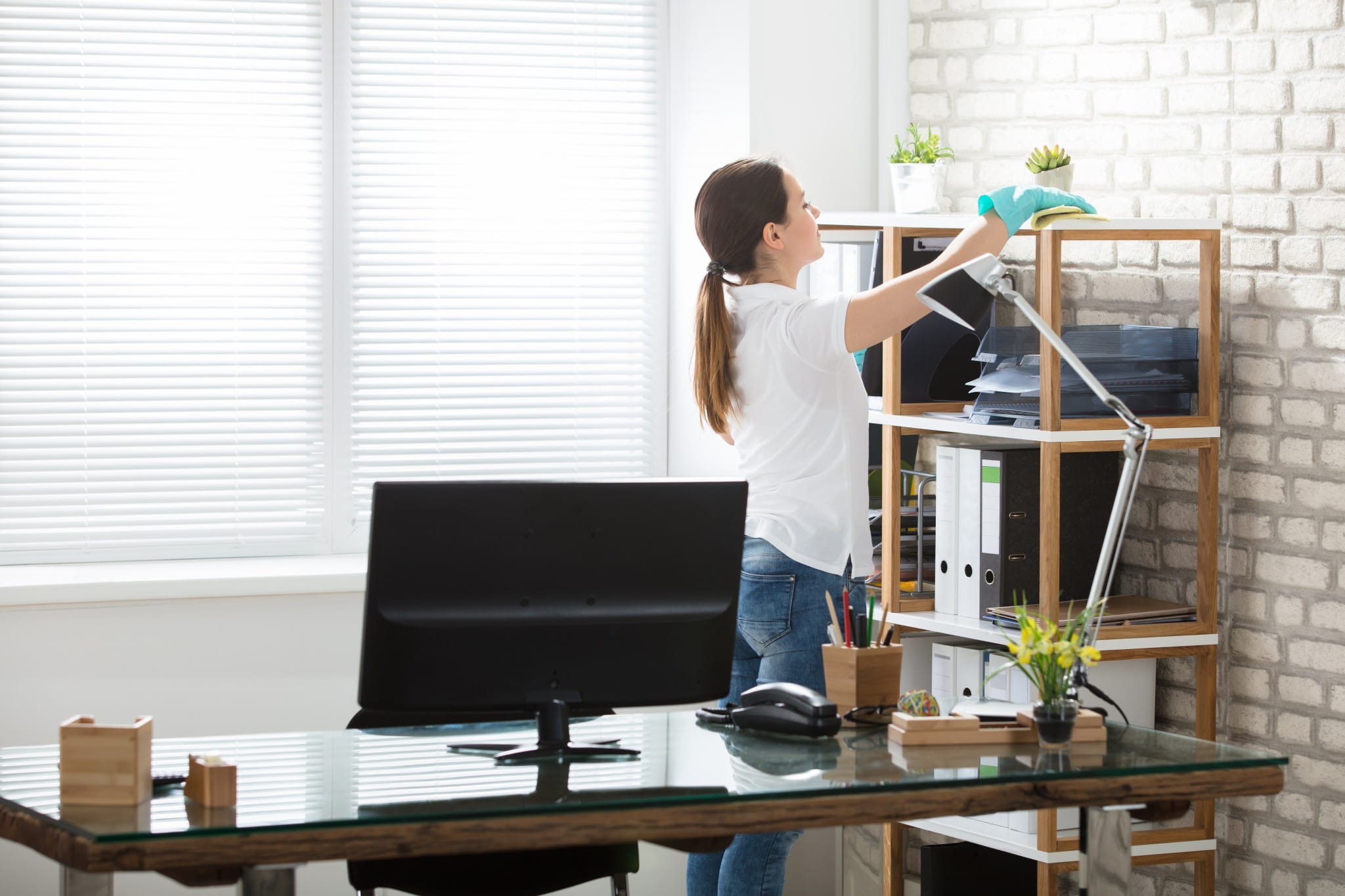 A woman cleans her office.